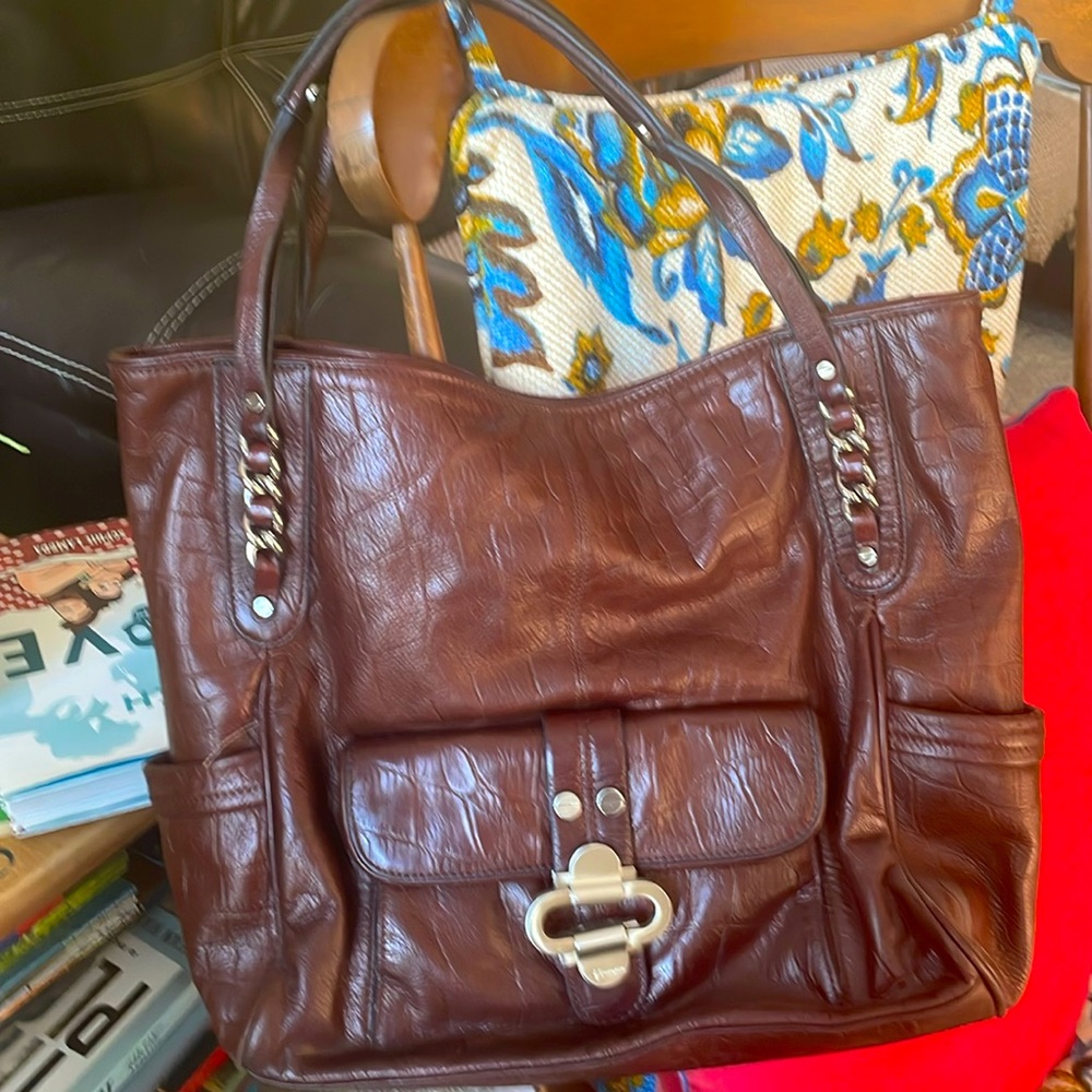 B. Makowsky brown leather purse with silver chain accents.